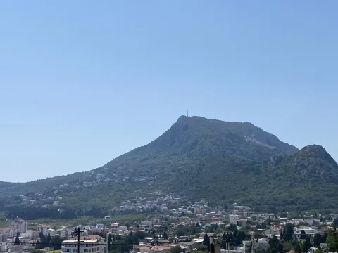 Pogled na planinu i naselje pod vedrim nebom. - image 13