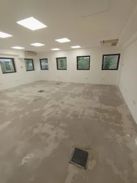 Spacious empty room in a grey phase with windows and ceiling lights. - image 5