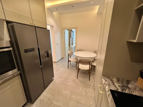 Modern kitchen with a dining table and built-in appliances. - image 2