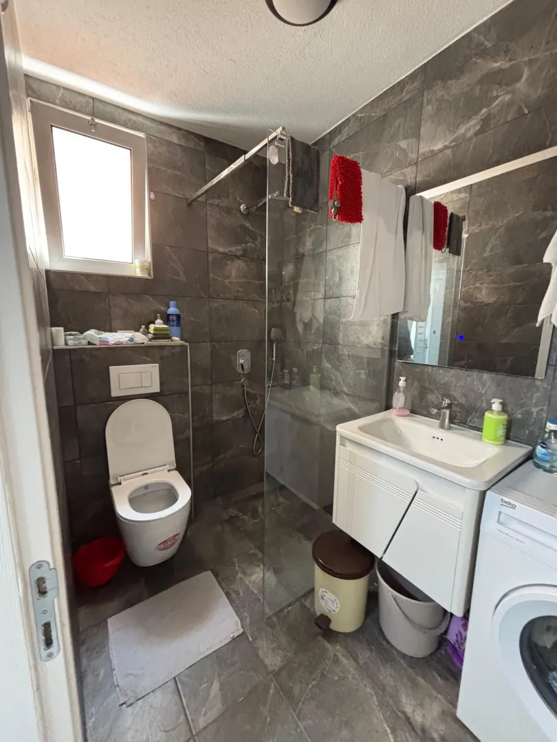 Manje kupatilo sa tuš kabinom, umivaonikom i wc šoljom.