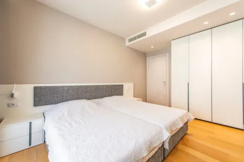 Spavaća soba sa bračnim krevetom, bijelim ormarom i drvenim podom. - image 18
