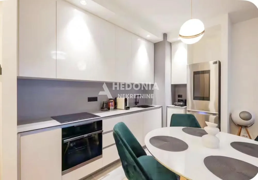 Modern kitchen with built-in appliances and a dining table.