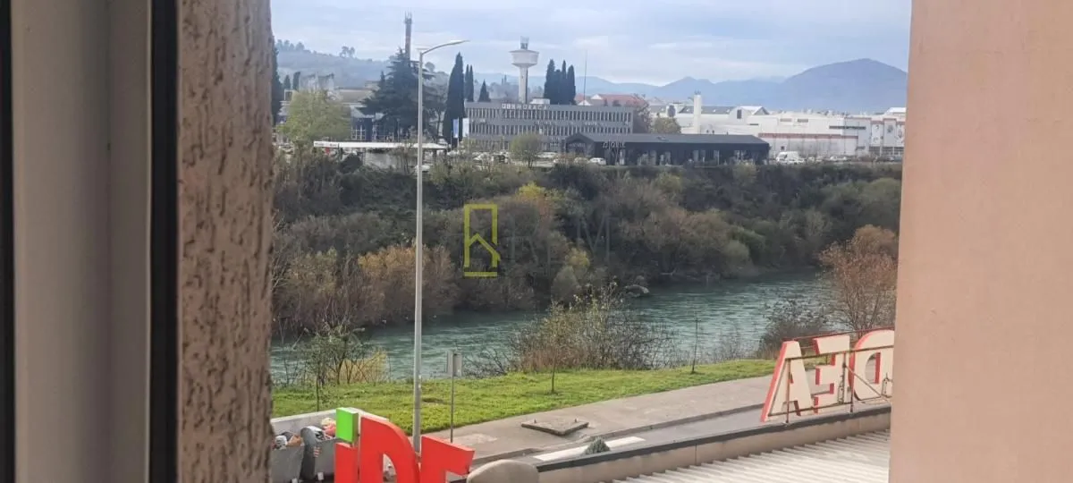 Pogled sa prozora na rijeku i okolne zgrade.