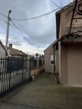 Dvorište kuće sa metalnom kapijom i popločanim prilazom. - image 4