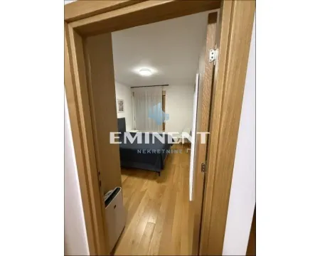 Pogled iz hodnika kroz vrata na nameštenu spavaću sobu. - image 7