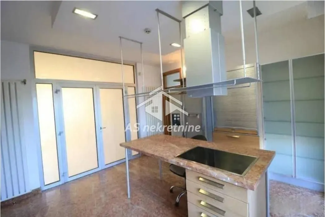 Kitchen with an island, range hood, and access to the terrace.