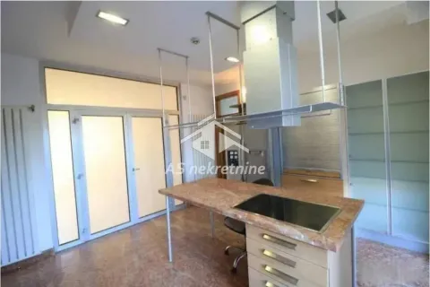 Kitchen with an island, range hood, and access to the terrace. - image 7