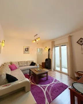 Living room with sofa, coffee table and wood-burning stove. - image 7