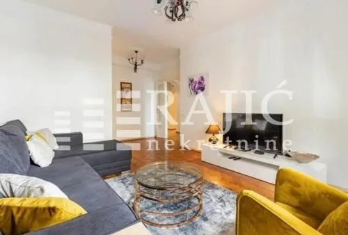 Spacious living room with a sofa and television.