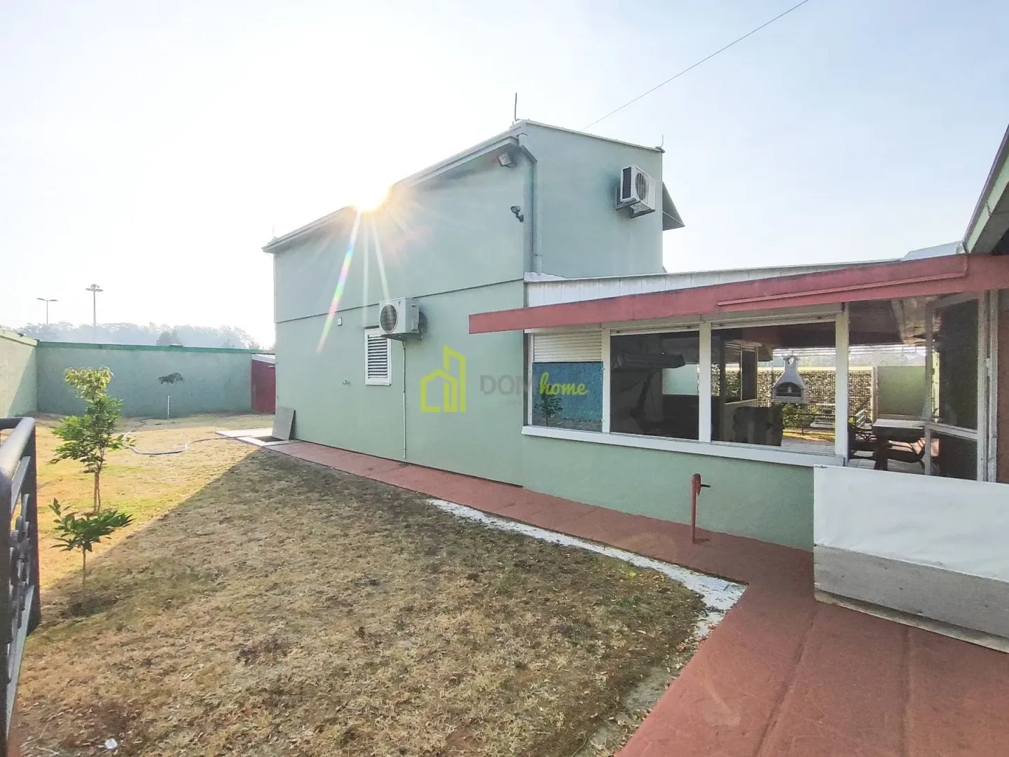Exterior view of the house with a yard and terrace.
