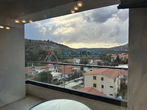 Natkrivena terasa sa staklenom ogradom i pogledom na naselje i brda. - image 20