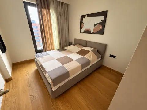 Moderna spavaća soba sa bračnim krevetom, drvenim podom i velikim prozorom. - image 2