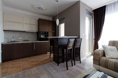 Modern kitchen with a bar and dining table connected to the living room. - image 3