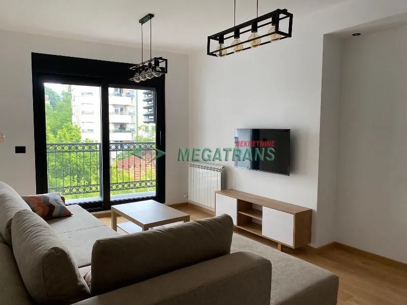 Living room with sofa, TV and access to the terrace.