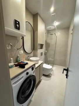 Moderno opremljeno kupatilo sa tuš kabinom, umivaonikom i veš mašinom. - image 2