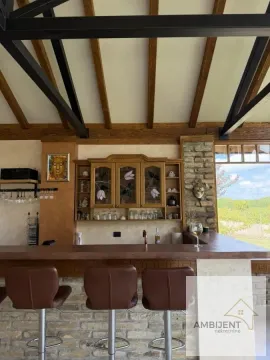 Rustična kuhinja sa šankom, drvenim gredama na plafonu i barskim stolicama. - image 3