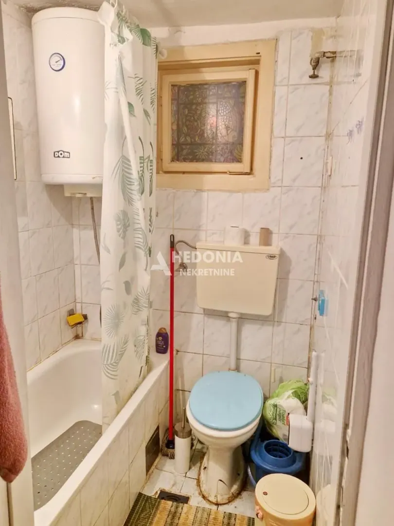 Manje kupatilo sa kadom, wc šoljom i bojlerom.