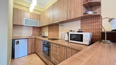 Kuhinja sa drvenim elementima, ugradnom rernom i mikrotalasnom. - image 3