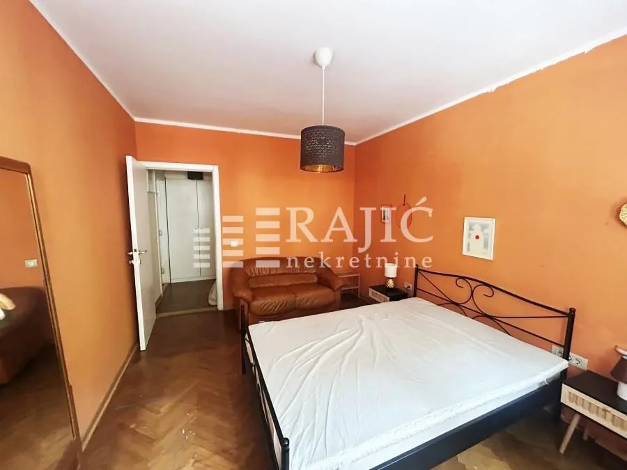 Bedroom with a double bed and orange walls.