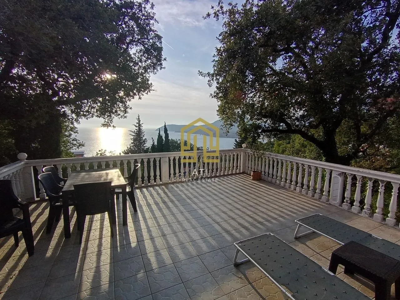 Prostrana terasa sa garniturom za sjedenje i pogledom na more.
