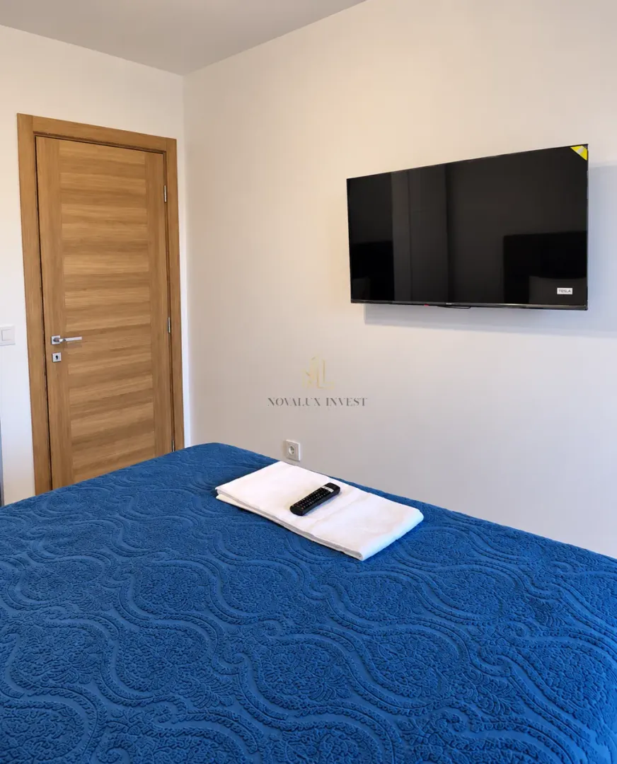 Bedroom with a bed and a wall-mounted TV.