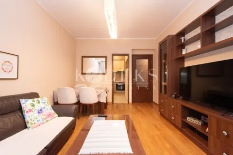 Living room with a sofa, TV unit and dining area in the background. - image 13