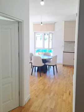 Trpezarija sa stolom i stolicama i dio kuhinje sa elementima. - image 12