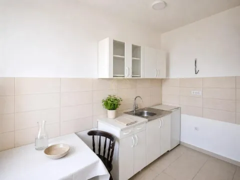 Manja bela kuhinja sa sudoperom, gornjim i donjim elementima i trpezarijskim stolom. - image 3