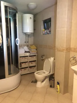 Bathroom with a shower cabin, toilet, and towel shelf. - image 26