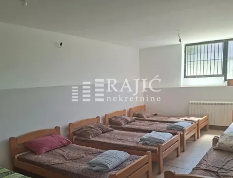 Spavaća soba sa više drvenih kreveta i posteljinom. - image 4