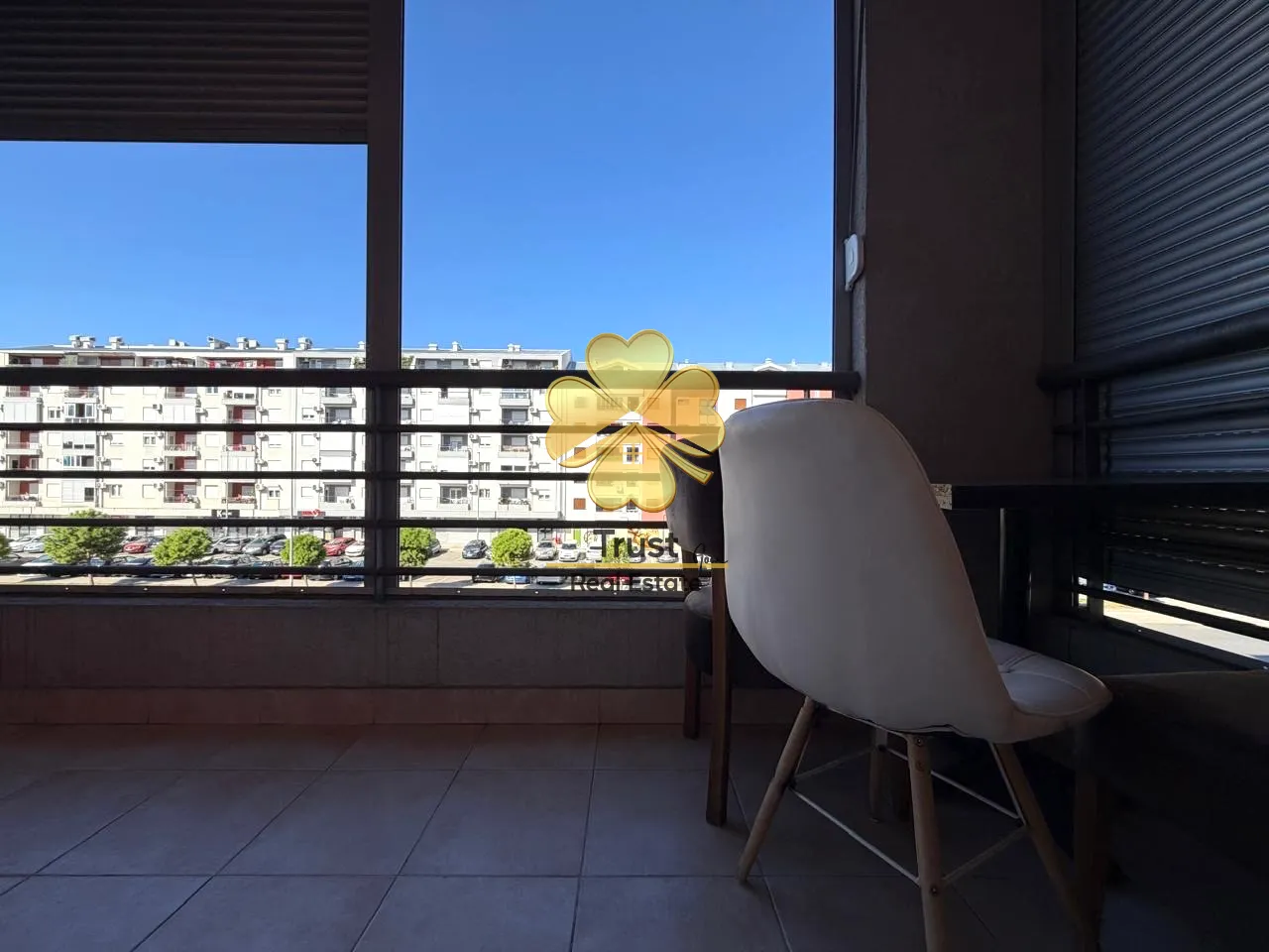 Covered terrace with a dining table and chairs and a city view.
