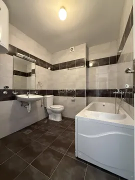 Bathroom equipped with a bathtub, washbasin, and toilet. - image 6
