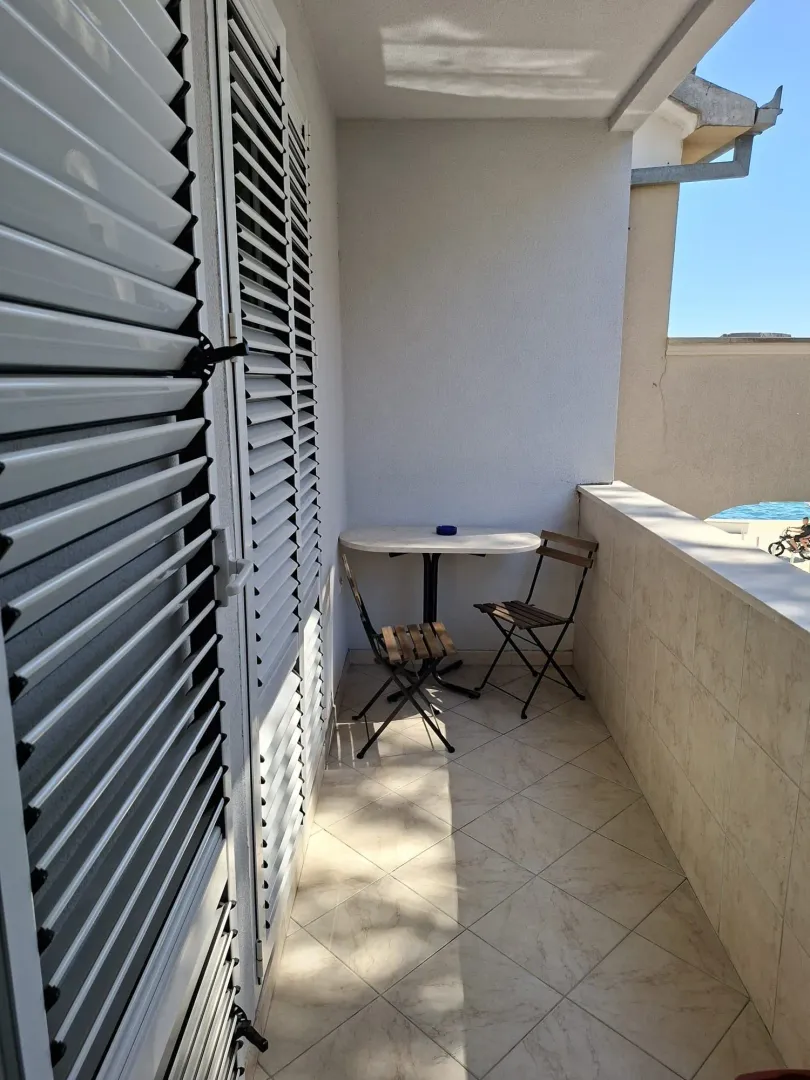 Manji balkon sa stolom i dve stolice.