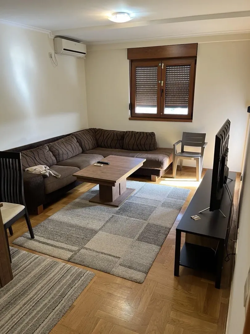 Bright living room featuring a corner sofa and television.