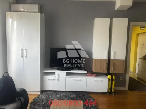 Dnevna soba sa televizorom, nameštajem i belim ormarima. - image 3
