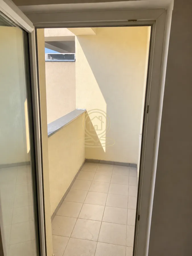 Pogled na popločanu terasu sa balkonskim vratima.