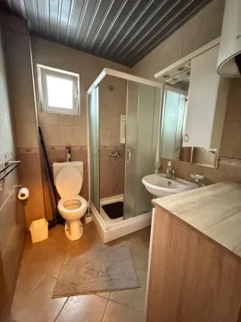 Manje opremljeno kupatilo sa tuš kabinom, umivaonikom i toaletom. - image 7