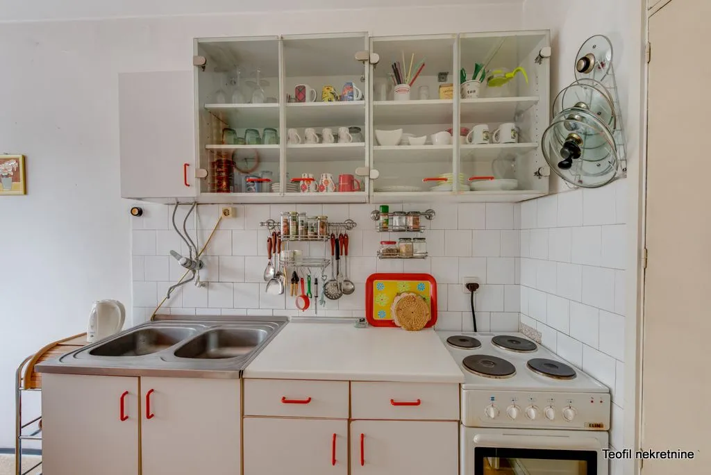 Kitchen with white units, a sink, and a stove.