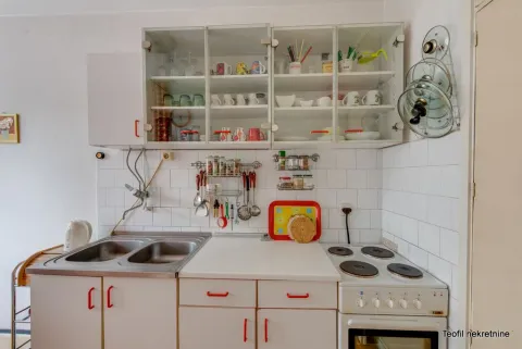 Kitchen with white units, a sink, and a stove. - image 15