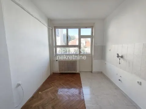 Prazna kuhinja sa prozorom i vratima koja vode na terasu. - image 7