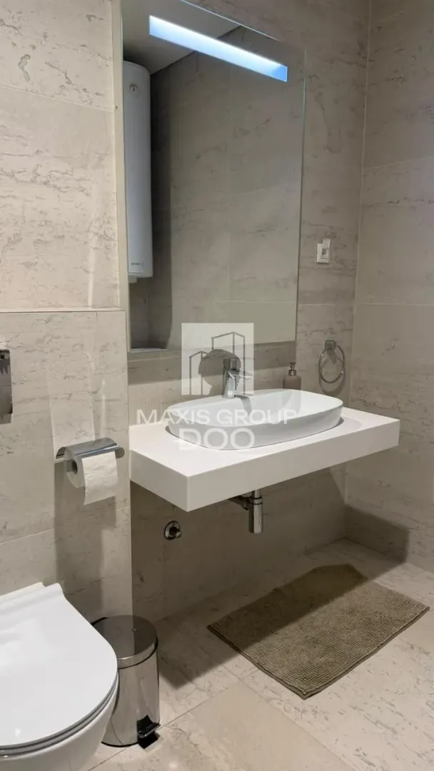 Moderno kupatilo sa umivaonikom, ogledalom i wc šoljom.