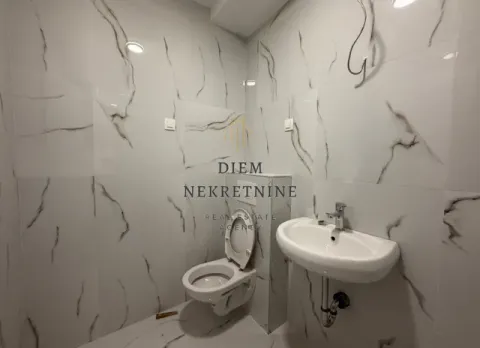 Small bathroom tiled with marble-pattern ceramic tiles. - image 7