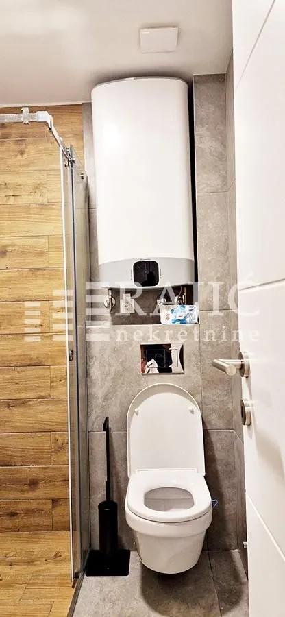 Modernly equipped bathroom with a walk-in shower and concealed cistern.