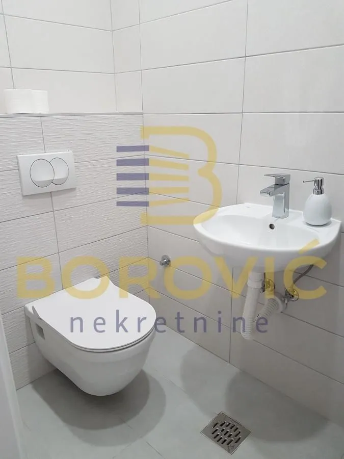 View of a modern bathroom equipped with a washbasin and toilet.
