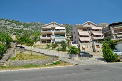 Exterior view of multi-apartment buildings with terraces and a driveway at the foot of a mountain. - image 15