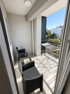 Natkriveni balkon sa crnim ratan namještajem i sušilicom za veš. - image 4