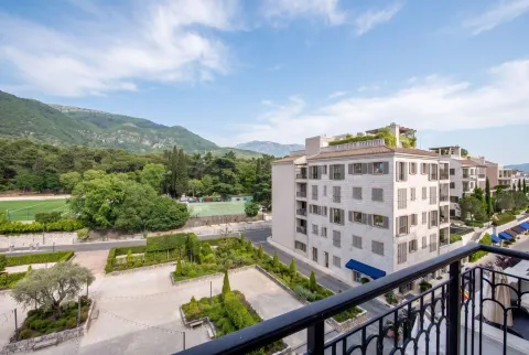 Pogled sa terase na uređeno dvorište, susjednu zgradu i okolne planine. - image 14