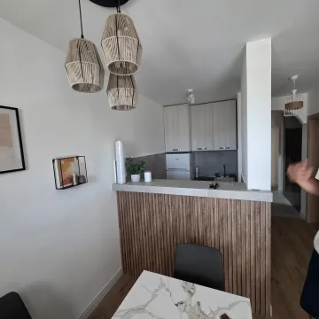 Small kitchen with a breakfast bar and dining table in an apartment. - image 11