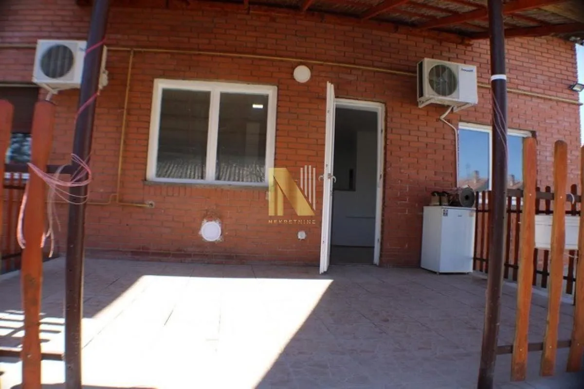 House terrace with a brick facade and entrance door.
