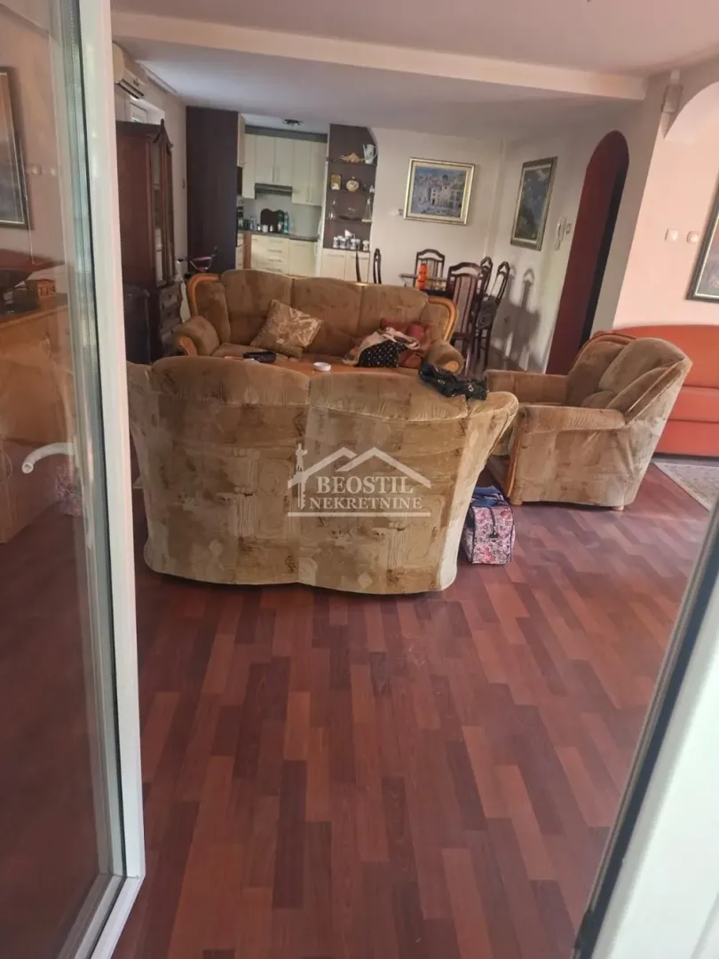Living room with a sofa set and a view of the dining area and kitchen.